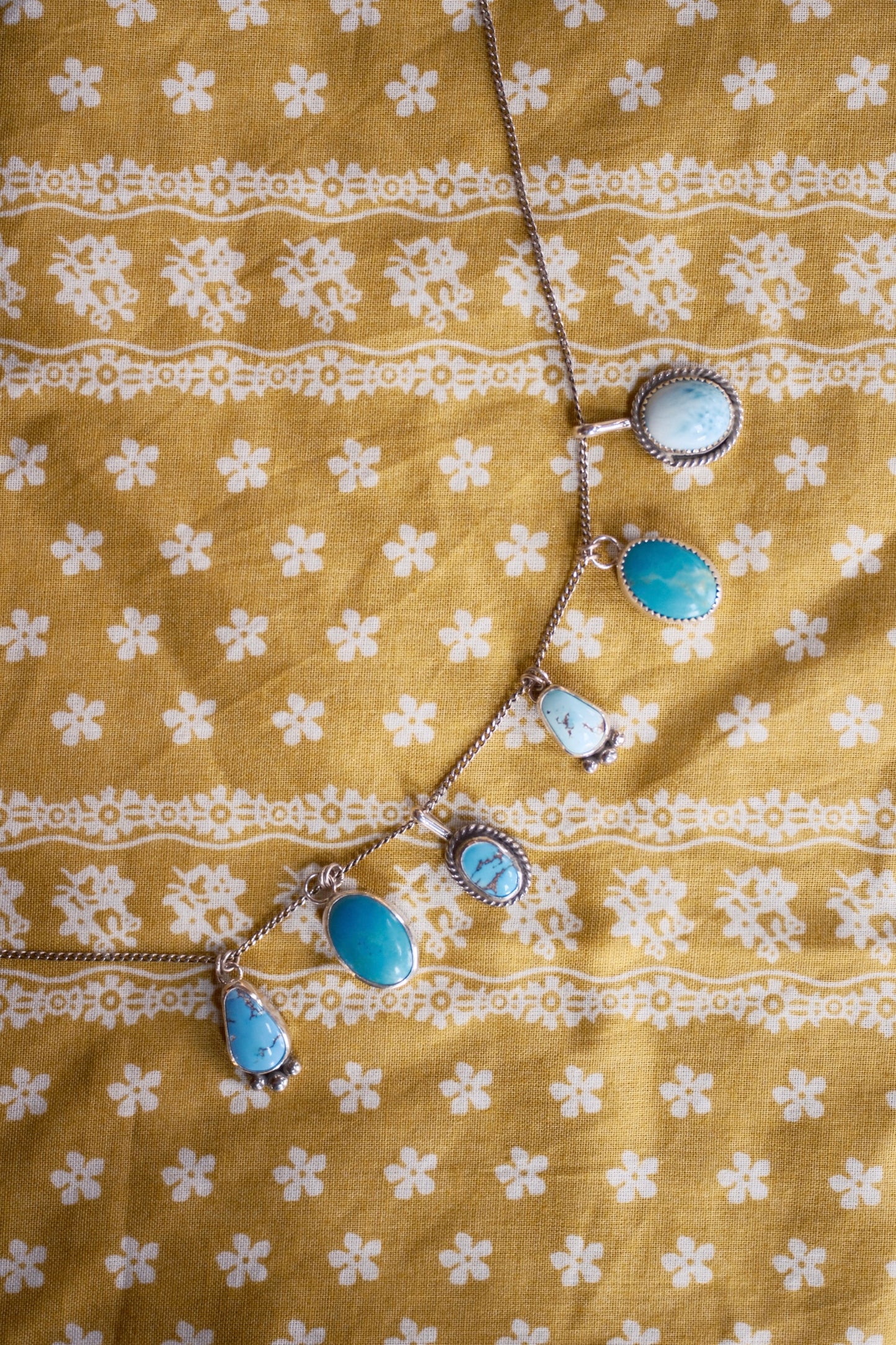 Necklace with blue stones on a yellow fabric background