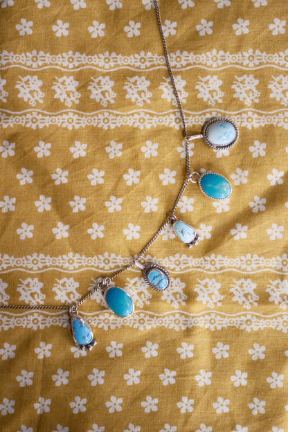 Necklace with blue stones on a yellow fabric background